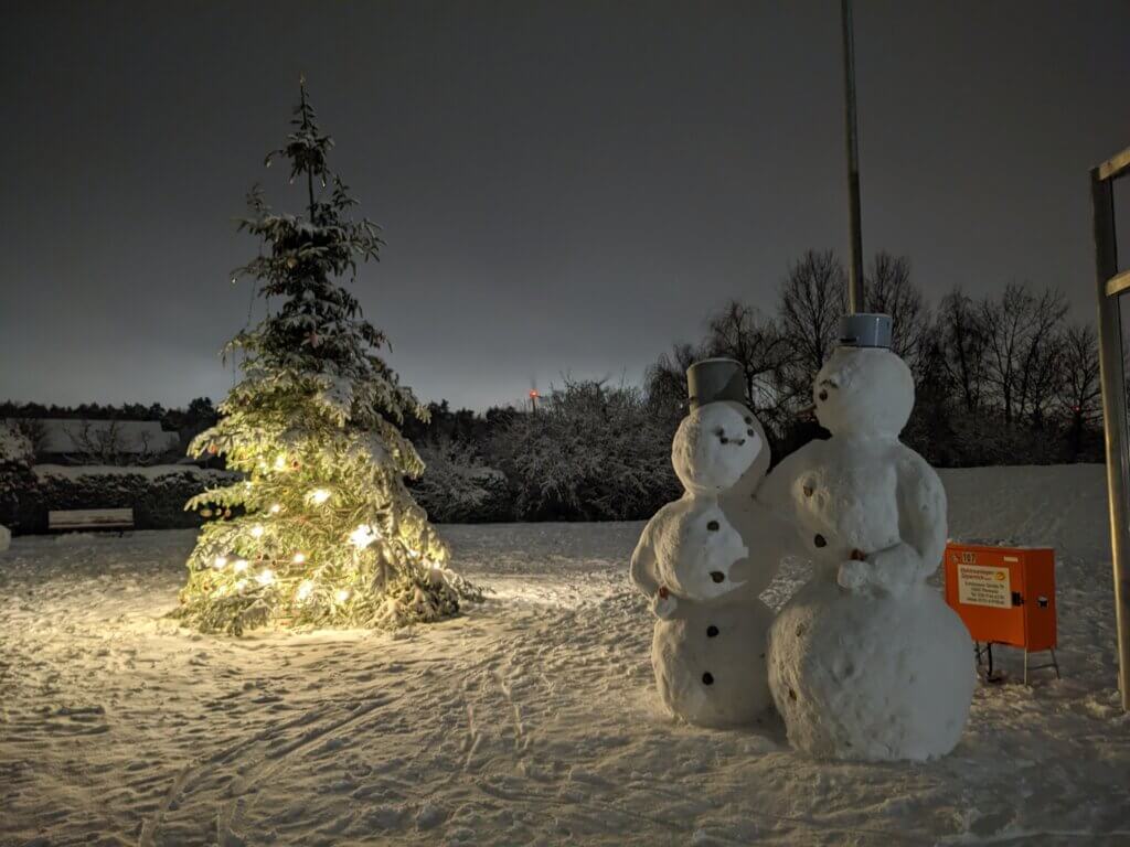 Zwei Schneemänner vor Weihnachtsbaum